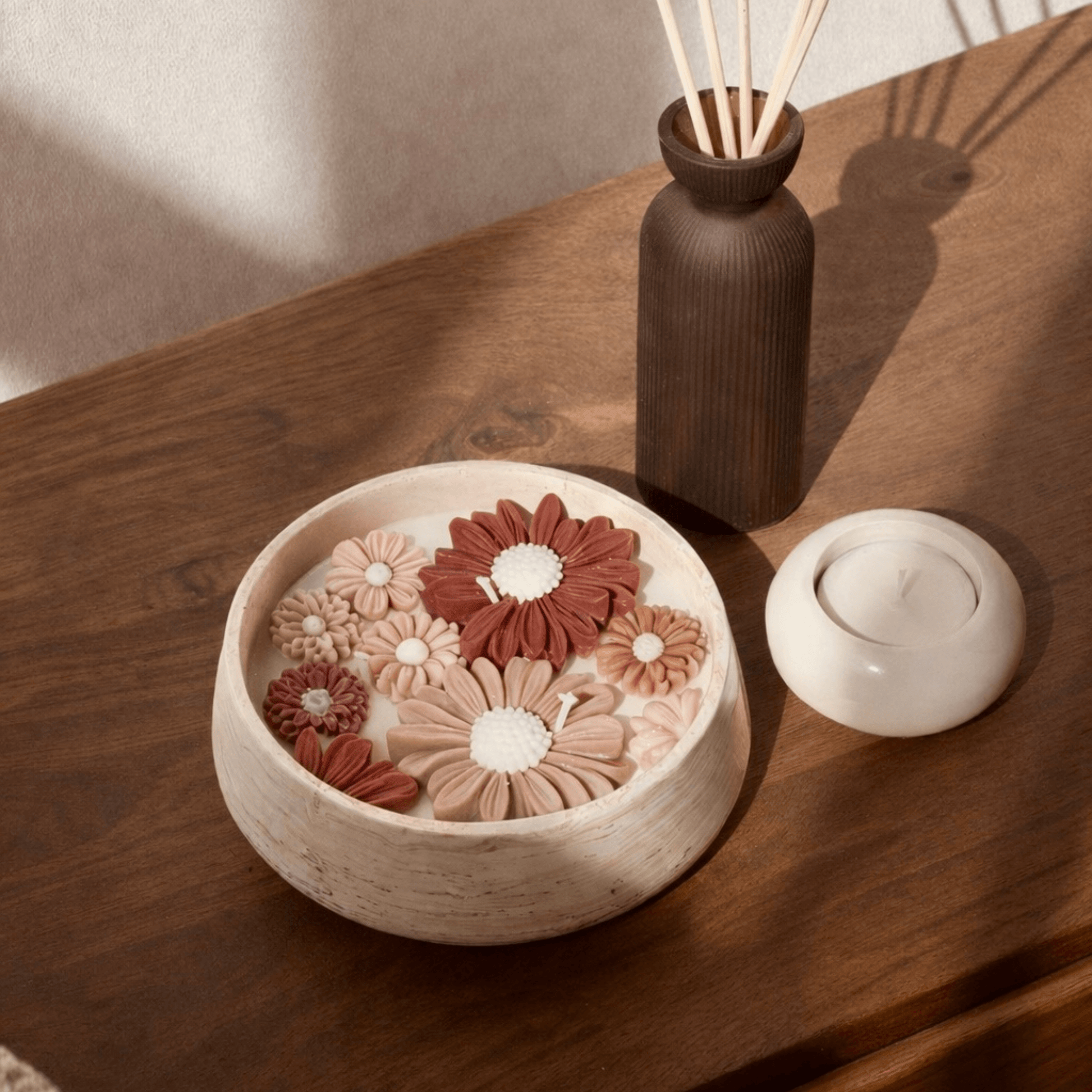 Blossom geurkaars met essentiële oliën op donkerhouten tafel naast waxinelichthouder kiera