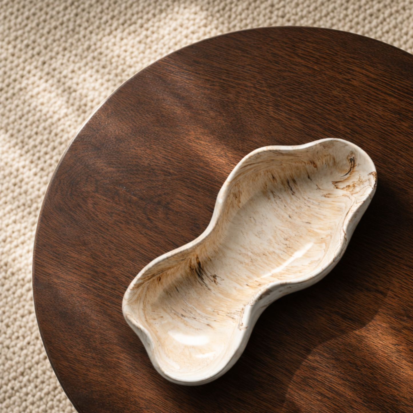 Dune decoratieve schaal van Pebbles en LouLou met organische vorm in beige en bruin tinten op donker houten ronde salontafel