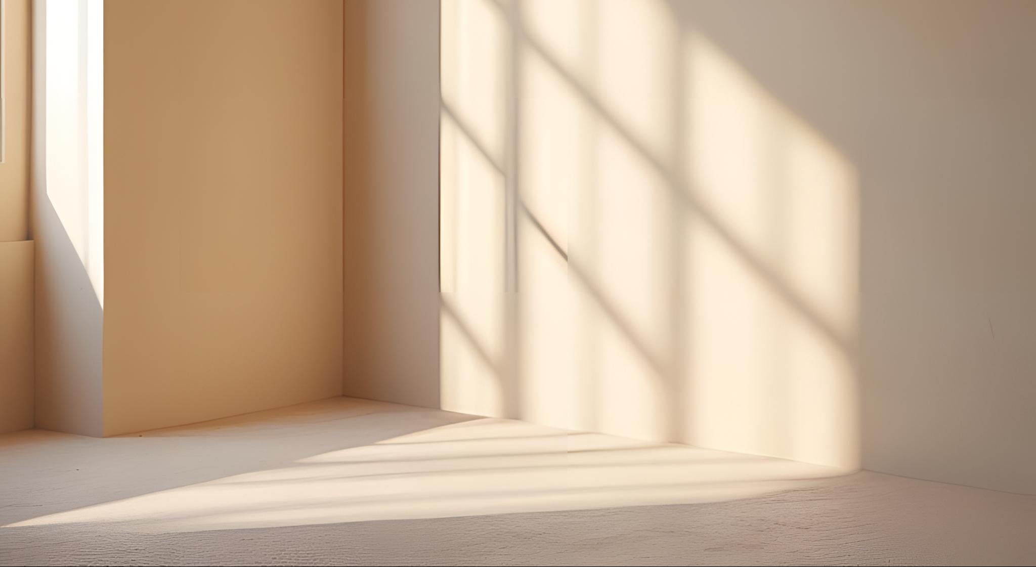 Een_lichte_zand-kleurige_hoek_van_een_lege_kamer_met_een_zachte_en_lichte_inval_van_zonlicht_waardoor_er_een_zachte_en_wazige_schaduw_op_de_muur_valt