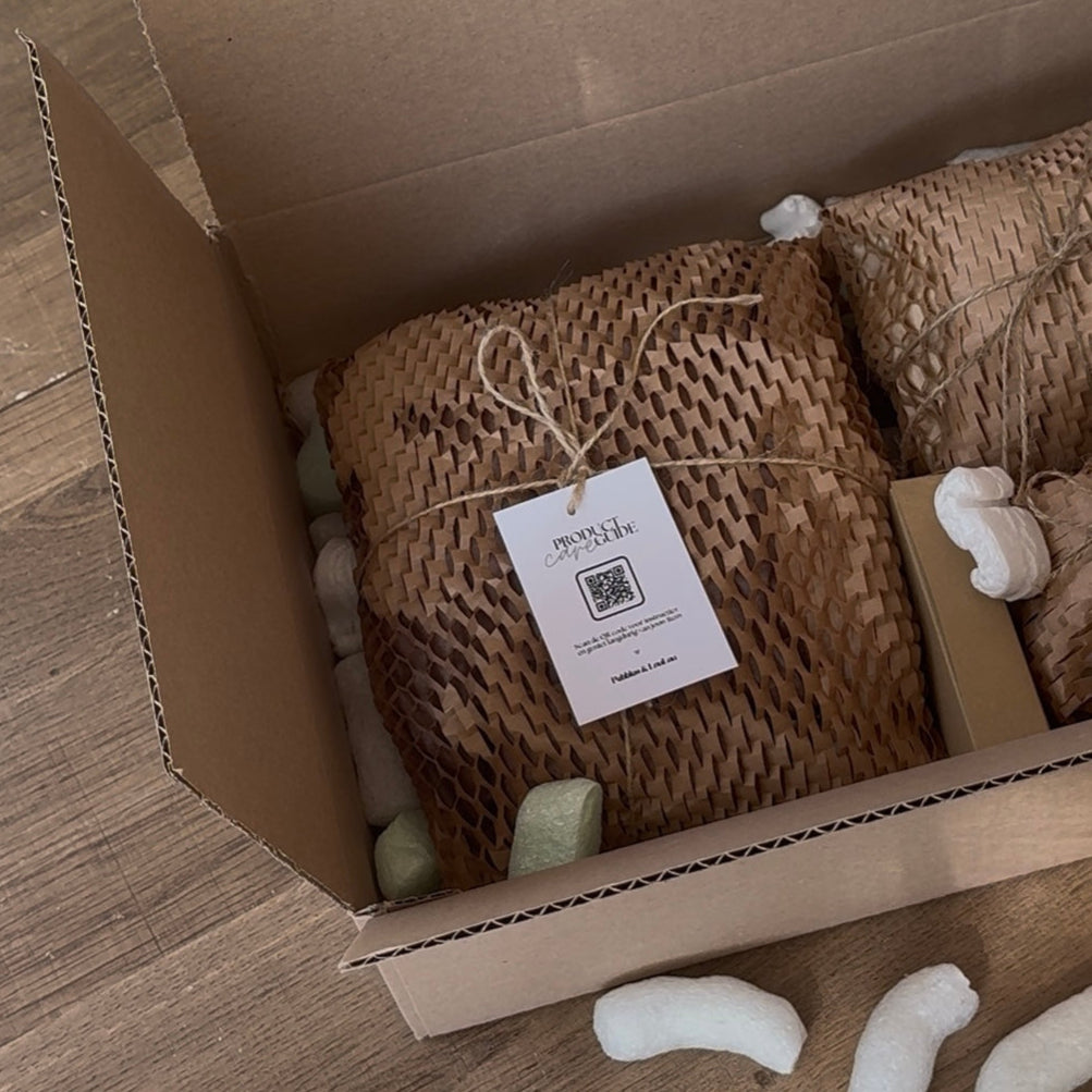 Verzenddoos met in gerecycled kraftpapier verpakte woonaccessoires van Pebbles en LouLou
